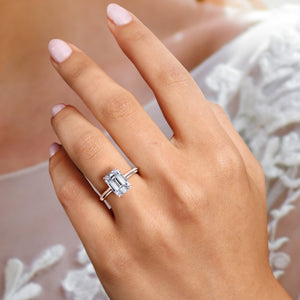 Elegant emerald ring with hidden halo on model's hand, crafted in 14K or 18K rose gold, perfect for any occasion.