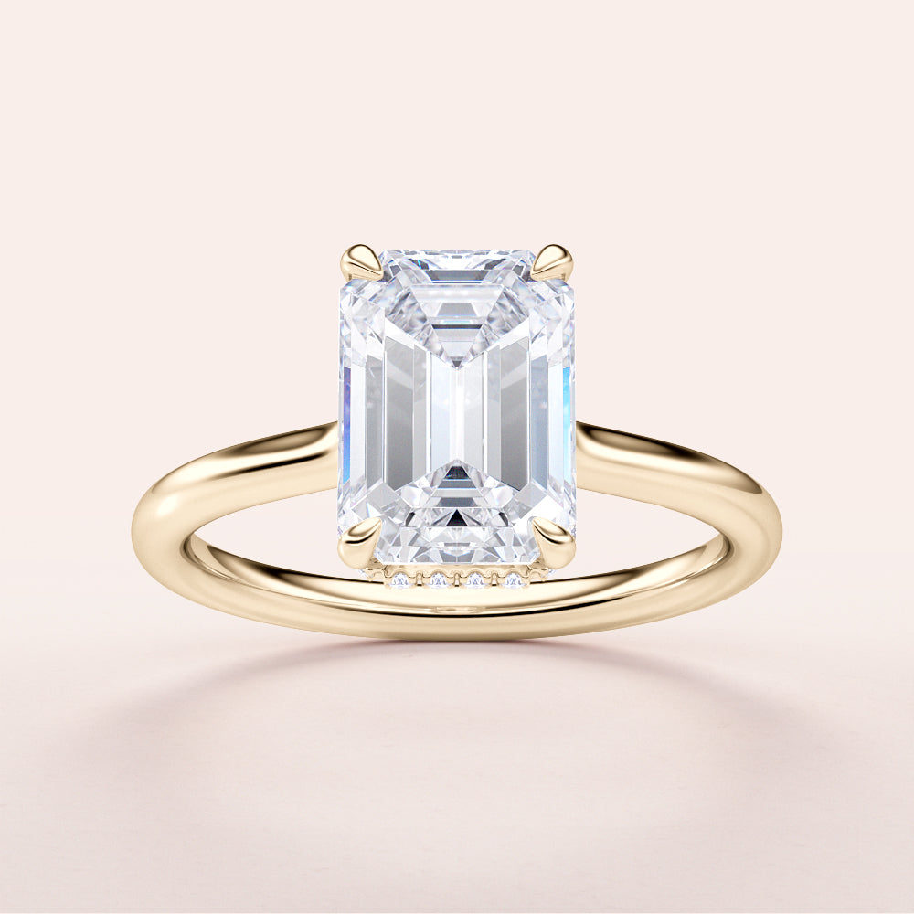 Elegant emerald-cut diamond solitaire engagement ring in yellow gold, available in 14K, 18K, or platinum, featuring a hidden halo.
#14KRecycledYellowGold
#18KRecycledYellowGold