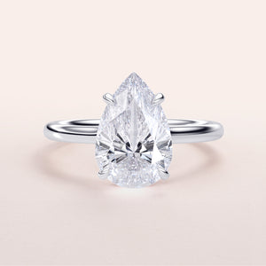 "Elegant pear-shaped diamond engagement ring in 14K or 18K gold and platinum, featuring a hidden halo and polished band."