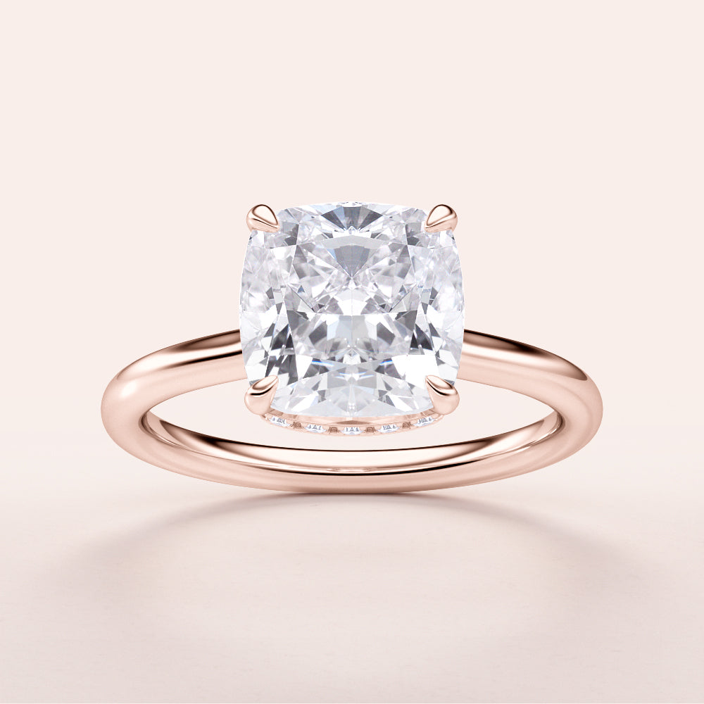 "Elegant 14K rose gold engagement ring featuring cushion-cut diamond with hidden halo. Jewelry piece not worn on model."