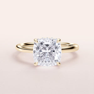 Elegant 14K/18K gold cushion-cut diamond engagement ring with hidden halo, featured on a minimalist background.