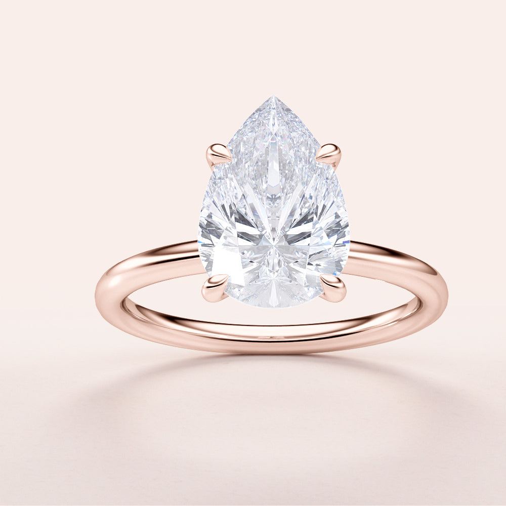 Elegant pear-shaped diamond ring in 14K or 18K rose gold, featuring a classic solitaire design, perfect for engagements.|







#14KRecycledRoseGold
#18KRecycledRoseGold


