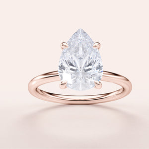 Elegant pear-shaped diamond ring in 14K or 18K rose gold, featuring a classic solitaire design, perfect for engagements.