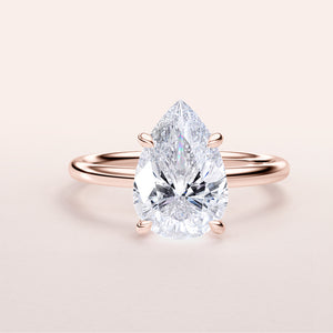 Elegant pear-shaped diamond solitaire engagement ring in 14K/18K rose gold, featuring a dazzling center stone.