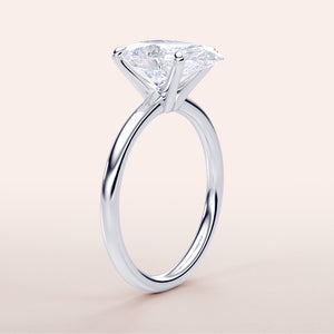 Elegant 14K/18K gold or platinum solitaire engagement ring with a stunning pear-cut diamond, showcasing timeless design and brilliance.