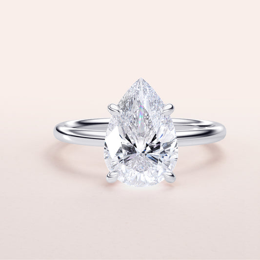 Elegant pear-shaped diamond engagement ring in 14K or 18K white gold or platinum setting, showcasing timeless beauty and sophistication.