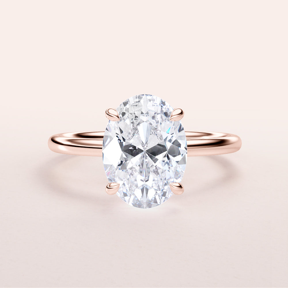 Rose gold engagement ring featuring an oval diamond in a classic solitaire design, available in 14K, 18K, or platinum.