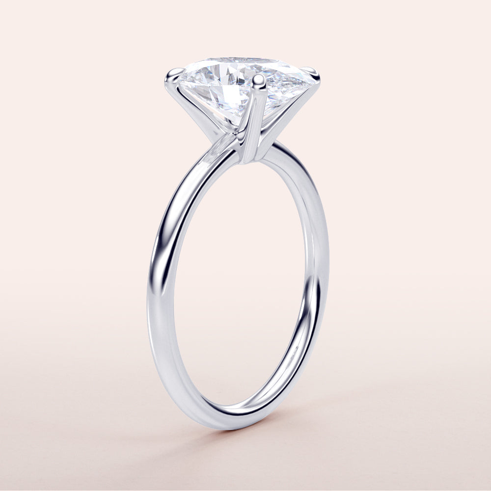 Elegant 14K white gold oval classic solitaire engagement ring featuring a round-cut diamond in a timeless prong setting.
