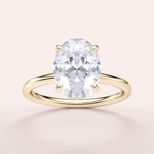 Elegant 14K/18K yellow gold engagement ring featuring an oval diamond center stone on a plain light background.