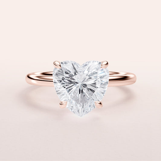 Heart-shaped diamond engagement ring in 14K or 18K rose gold, showcasing classic solitaire design. Shown unmodeled.
