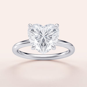 Elegant heart-shaped diamond engagement ring in 14K, 18K, or platinum, displayed on a neutral background.