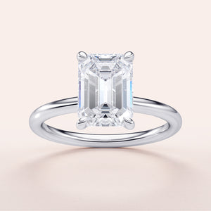 Emerald-cut diamond engagement ring in 14K or 18K white gold, showcasing an elegant solitaire design. Not worn on model.