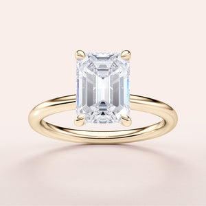Elegant emerald cut diamond solitaire ring in a slim 14K or 18K gold band, showcasing timeless sophistication.