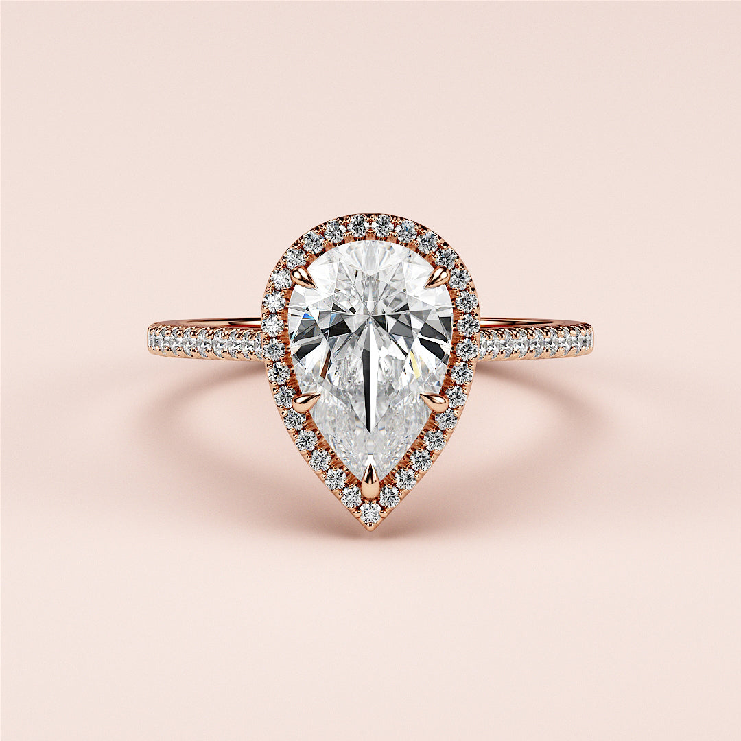 Elegant pear-shaped diamond ring with halo setting in 14K/18K rose gold, perfect for engagements and special occasions.