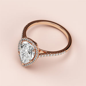 Elegant rose gold engagement ring with pear-shaped diamond center, halo, and pave band. Available in 14K, 18K, and platinum.