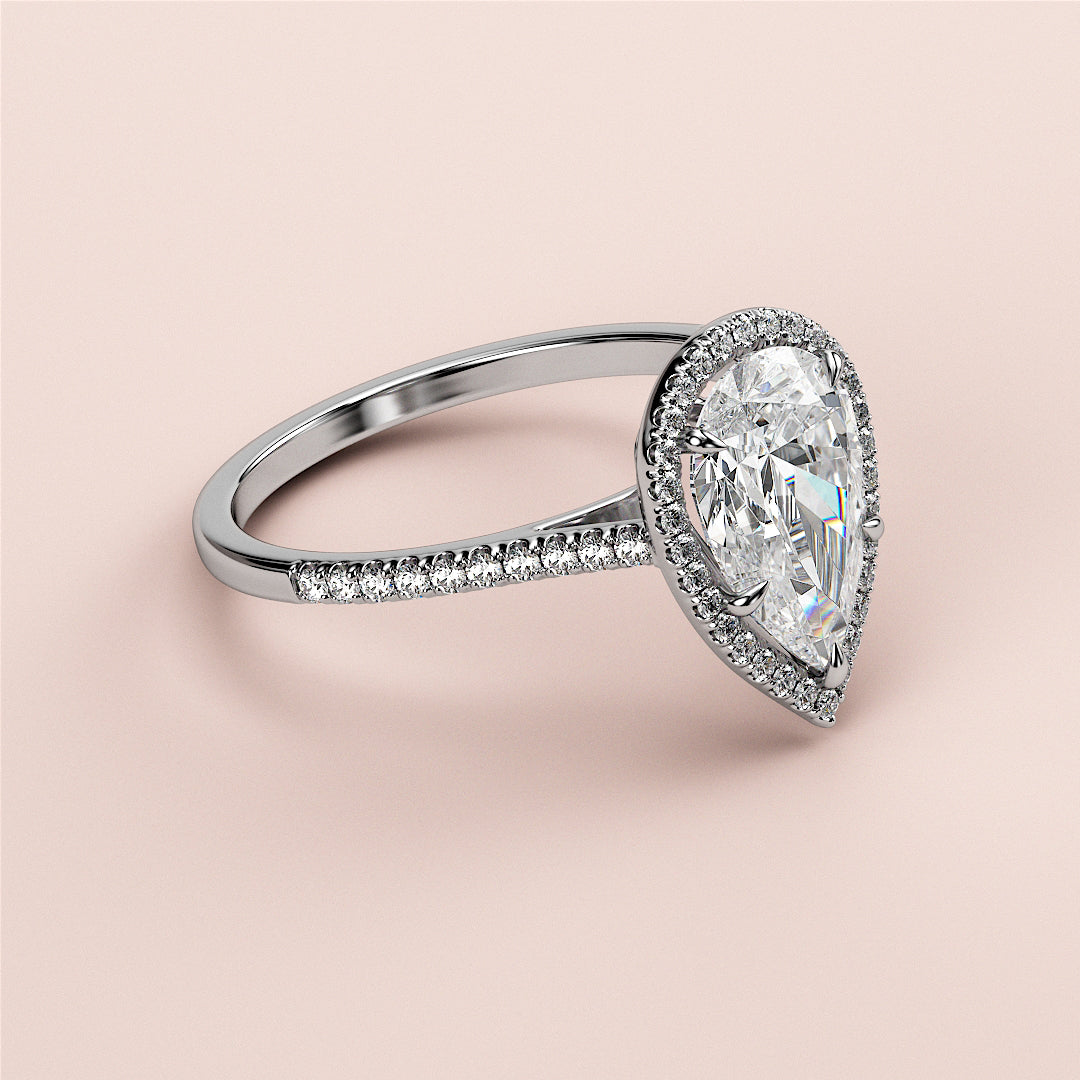 Exquisite pear-shaped diamond engagement ring in 14K/18K gold or platinum, featuring a halo setting and diamond-accented band.