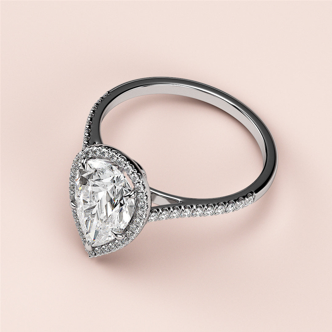 Elegant pear-shaped diamond engagement ring in 14K or 18K gold or platinum, adorned with delicate pave-set diamonds.