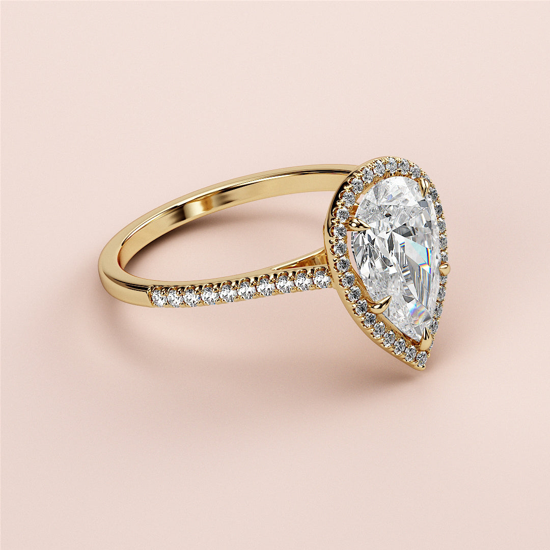 "Elegant pear-shaped diamond engagement ring in 14K gold with a pave diamond band, exuding timeless sophistication."