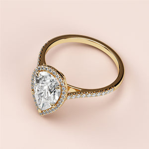 Elegant 14K or 18K yellow gold engagement ring featuring a pear-shaped diamond in a halo setting with pave band detail.