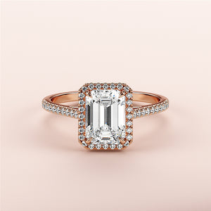 Elegant emerald halo engagement ring in rose gold, featuring aPave band, available in 14K, 18K, or platinum.
