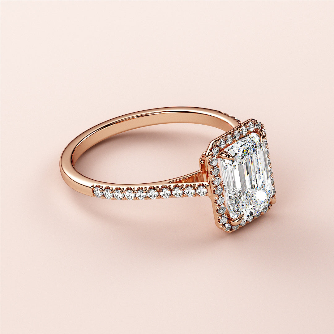 Elegant 14K rose gold emerald-cut diamond engagement ring with a dazzling halo, perfect for timeless sophistication.