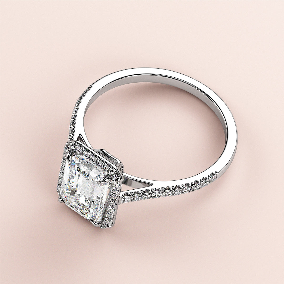 Elegant emerald-cut diamond engagement ring with halo setting in 14K/18K white gold, featuring a fine diamond-studded band.