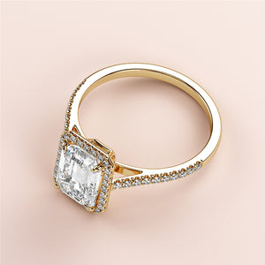 Elegant yellow gold engagement ring featuring a radiant-cut diamond in a halo setting with pave band; available in 14K, 18K, or platinum.