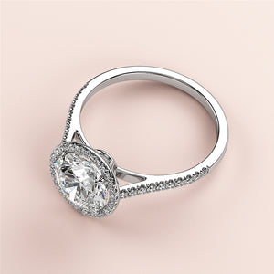 Elegant 14K white gold engagement ring featuring a round halo and pave band, adorned with sparkling diamond accents.
