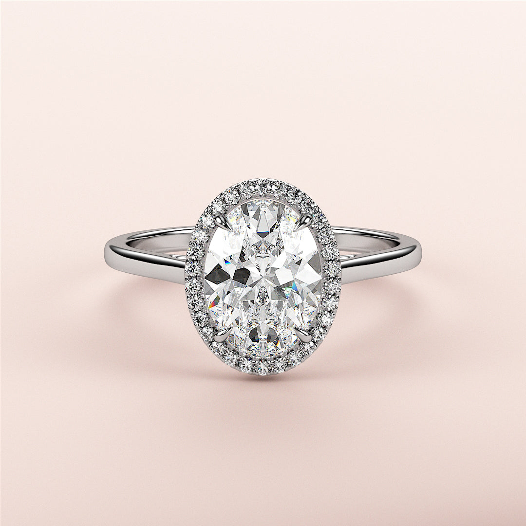 Elegant oval diamond halo engagement ring in white gold, available in 14K, 18K, or platinum, set against a soft pink background.|

#14KRecycledWhiteGold
#18KRecycledWhiteGold








#Platinum