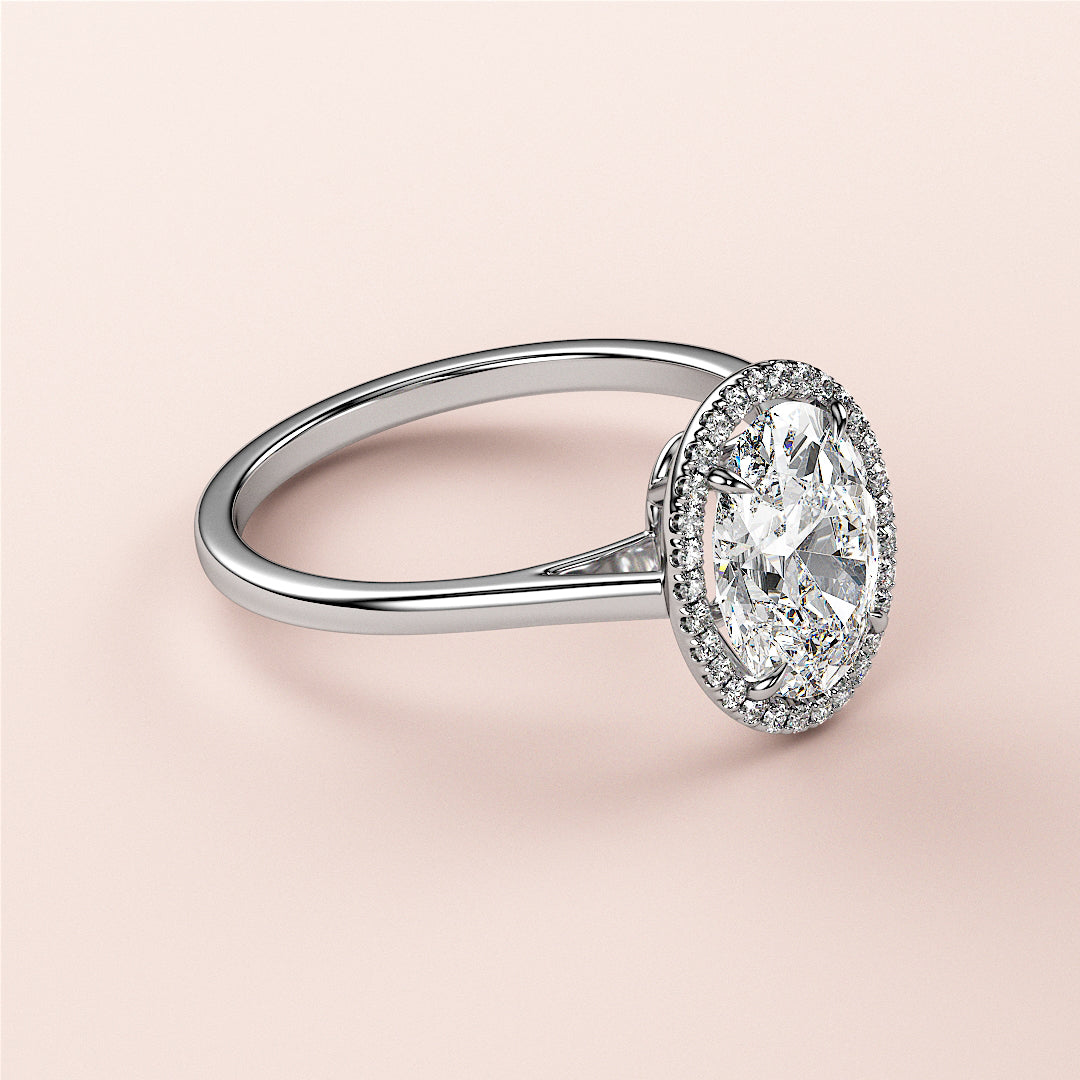 Elegant 14K white gold oval-cut diamond ring with halo setting, displayed on a model's finger. Timeless bridal jewelry.|

#14KRecycledWhiteGold
#18KRecycledWhiteGold








#Platinum