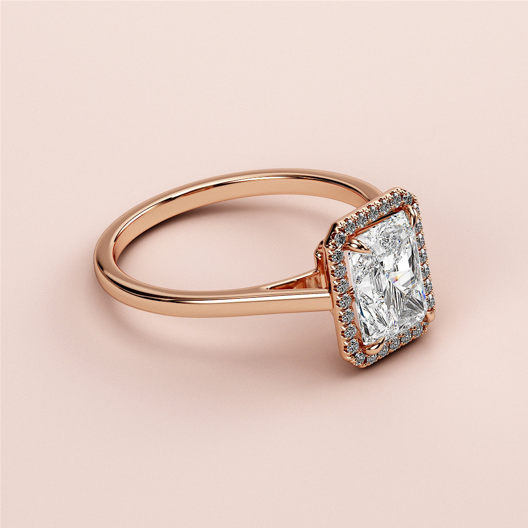 Elegant 14K or 18K rose gold engagement ring with radiant halo and rectangular-cut diamond, featuring a sparkling diamond band.|







#14KRecycledRoseGold
#18KRecycledRoseGold


