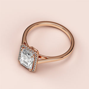 Radiant cut diamond engagement ring with halo setting in 14K/18K rose gold, displayed on a soft background.