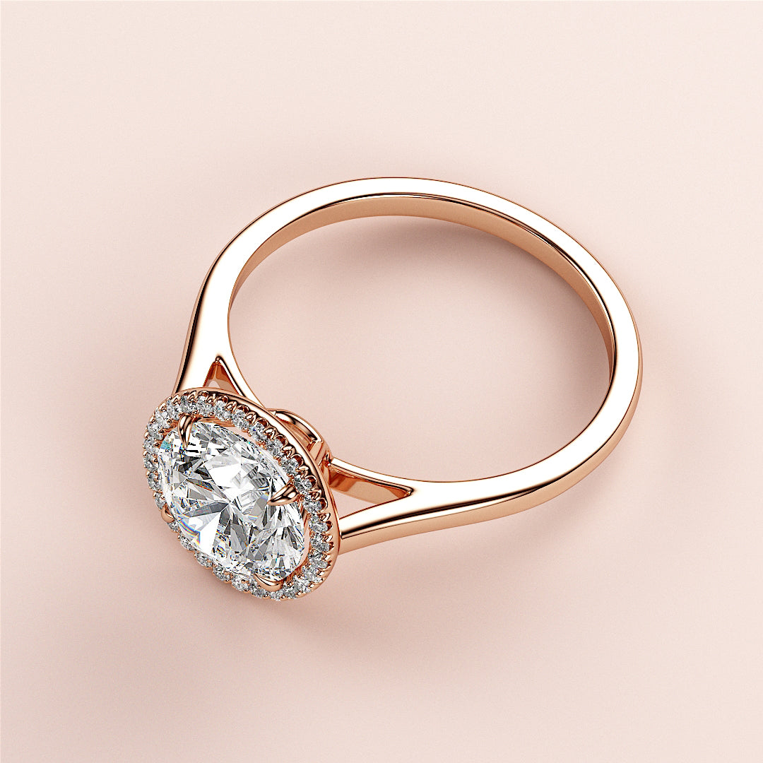 Elegant 14K rose gold engagement ring featuring a round halo diamond, showcased on a soft pink background.|







#14KRecycledRoseGold
#18KRecycledRoseGold


