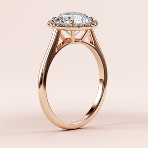 Elegant rose gold engagement ring with a round brilliant-cut diamond in a halo setting, crafted in 14K or 18K gold for timeless beauty.