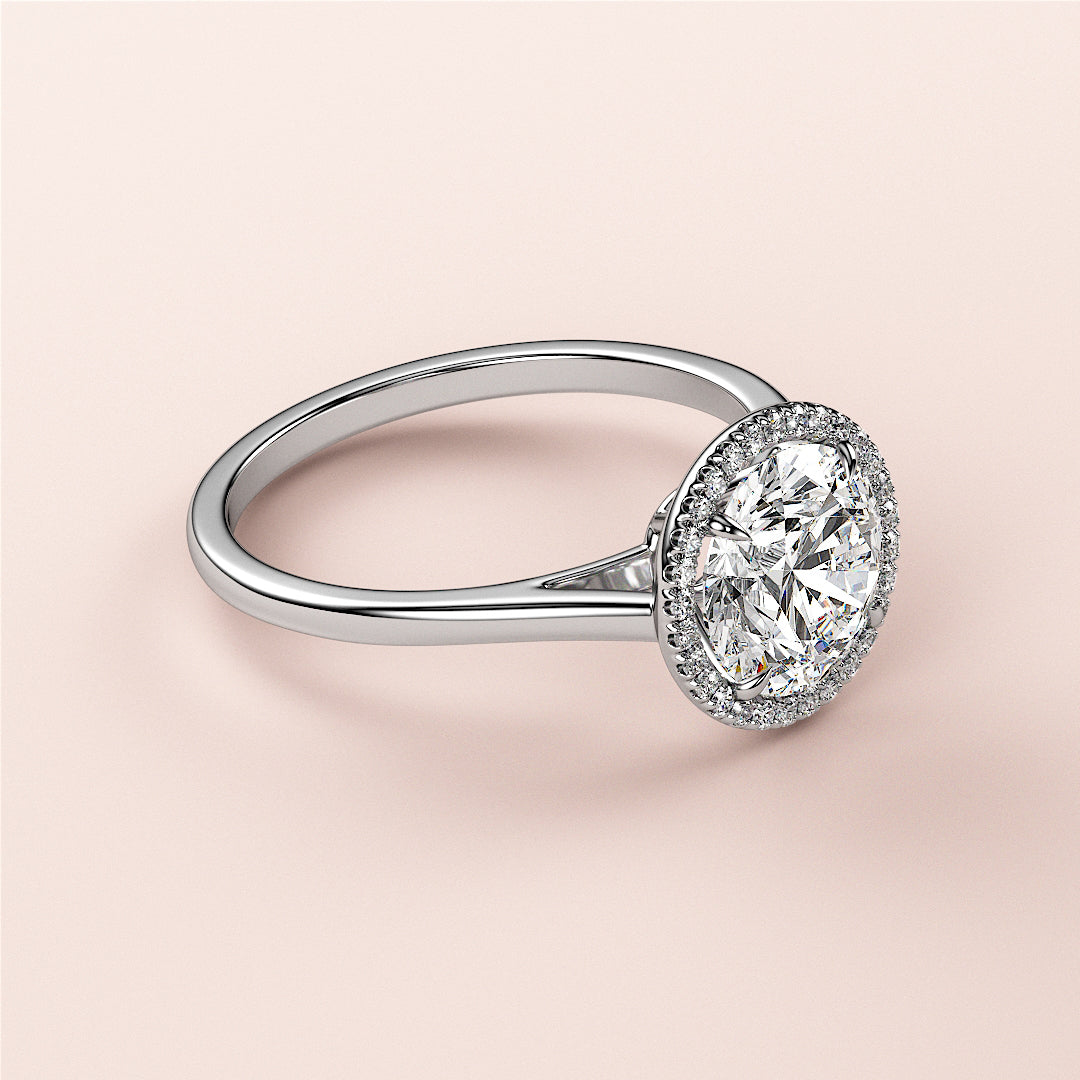 Elegant 14K white gold engagement ring with a halo setting, featuring an oval-cut diamond, on a light pink background.|

#14KRecycledWhiteGold
#18KRecycledWhiteGold








#Platinum