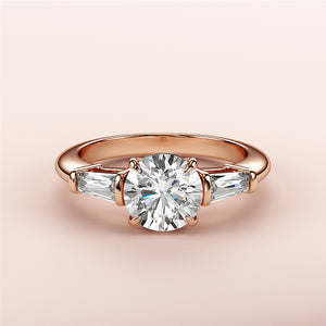 Elegant 14K rose gold engagement ring featuring a round diamond and tapered baguette accents. Perfect for special occasions.