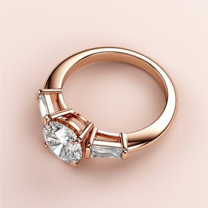 Elegant 14K rose gold engagement ring with oval-cut diamond and tapered baguette accents on a minimalist background.