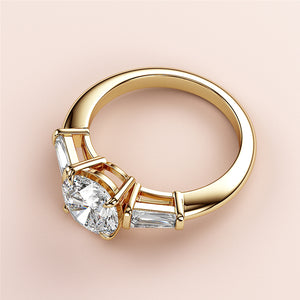 Elegant 14K/18K gold engagement ring featuring a central round diamond and tapered baguette side stones, perfect for proposals.