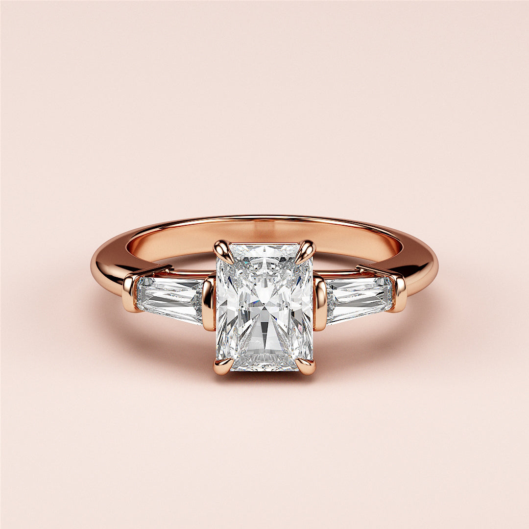 Radiant-cut diamond engagement ring with baguette side stones in a rose gold band, available in 14K, 18K, or platinum.