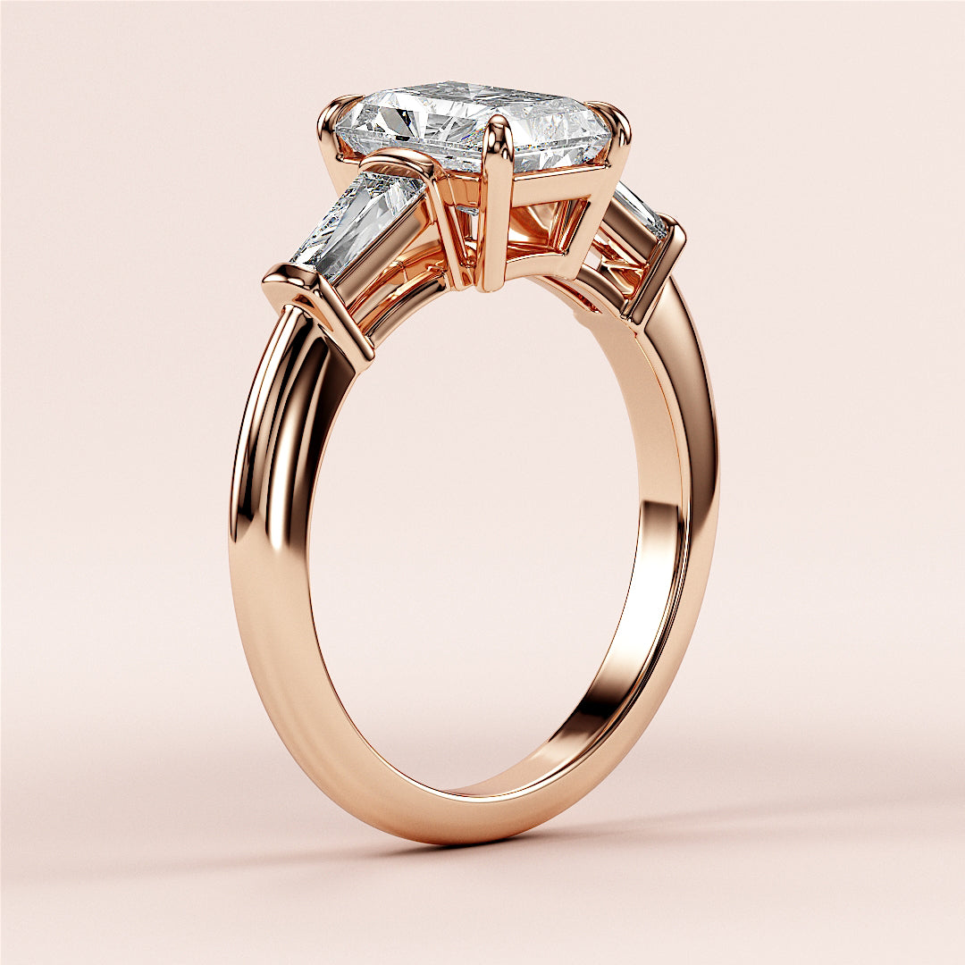 "Elegant 14K rose gold engagement ring with radiant three-stone tapered baguettes, showcasing a stunning diamond design."