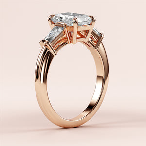 "Elegant 14K rose gold engagement ring with radiant three-stone tapered baguettes, showcasing a stunning diamond design."