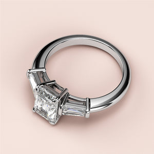 Elegant engagement ring with a radiant-cut diamond center and tapered baguette side diamonds in 14K or 18K white gold or platinum.