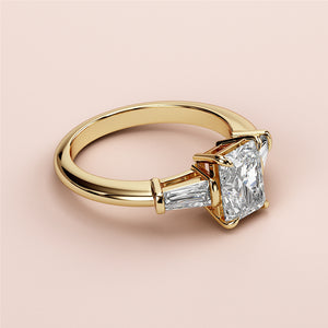 Elegant 14K or 18K gold engagement ring featuring a radiant-cut diamond center stone with tapered baguettes. Not worn on model.