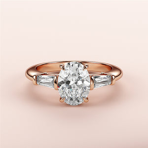 Elegant oval-shaped rose gold engagement ring with side baguette diamonds, available in 14K, 18K, or platinum.