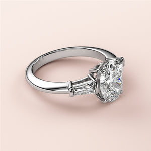 Elegant oval-shaped diamond engagement ring in 14K/18K white gold or platinum with tapered baguette diamonds for added brilliance.