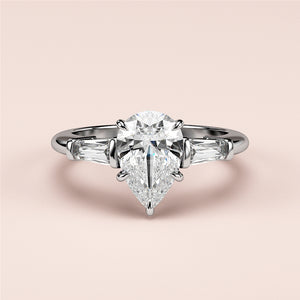 Elegant 14K or 18K white gold engagement ring with pear-shaped diamond center and tapered baguette diamonds.