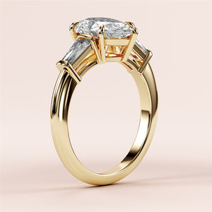 Elegant 14K yellow gold butterfly engagement ring with a pear-shaped diamond and tapered baguettes, showcasing exceptional craftsmanship.