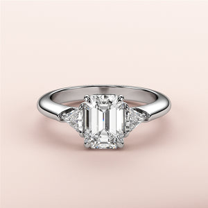 Elegant emerald-cut diamond engagement ring with two trillion-cut diamonds in 14K or 18K gold or platinum. Perfect for special occasions.