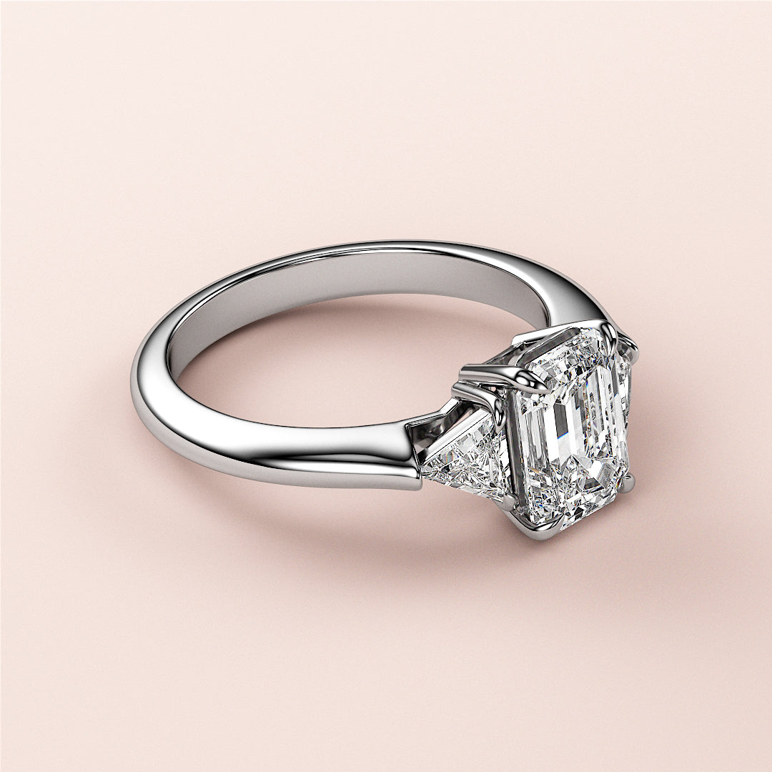 Elegant 14K or 18K white gold engagement ring featuring three emerald-cut stones in a stunning triangle setting.