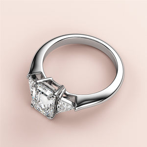 Elegant 14K white gold engagement ring featuring an Asscher-cut diamond in a three-stone setting, perfect for love and commitment.